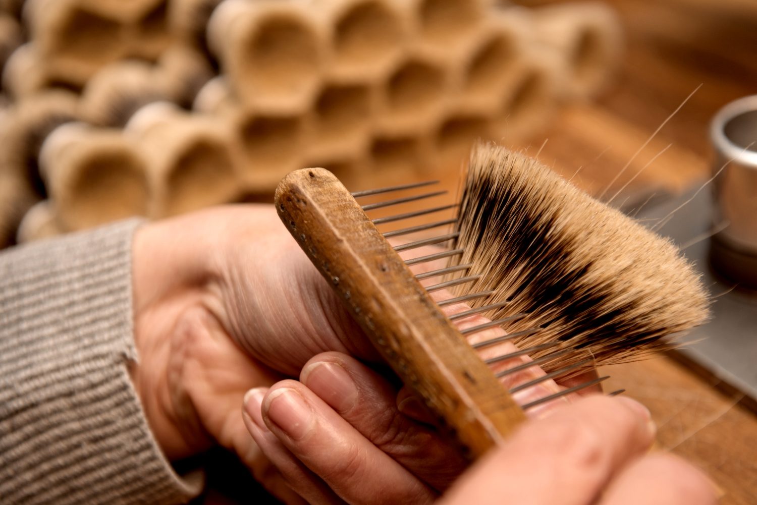 Manufakturen-Blog: Eine von Mühles Bürstenmacherinnen zeigt das Auskämmen quersitzender Dachshaare des Rasierpinsels (Foto: Manufakturhaus)