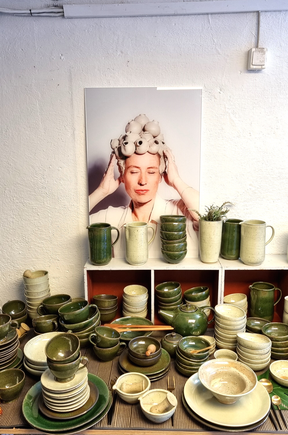 Manufakturen-Blog: Im Atelier-Verkauf bei Franziska M. Köllner in Leipzig mit Keramik-Geschirr im 'Vietnam-Köllner'-Grün - im Hintergrund ein Foto, das ihre Tochter von ihr gemacht hat. (Foto: Wigmar Bressel)